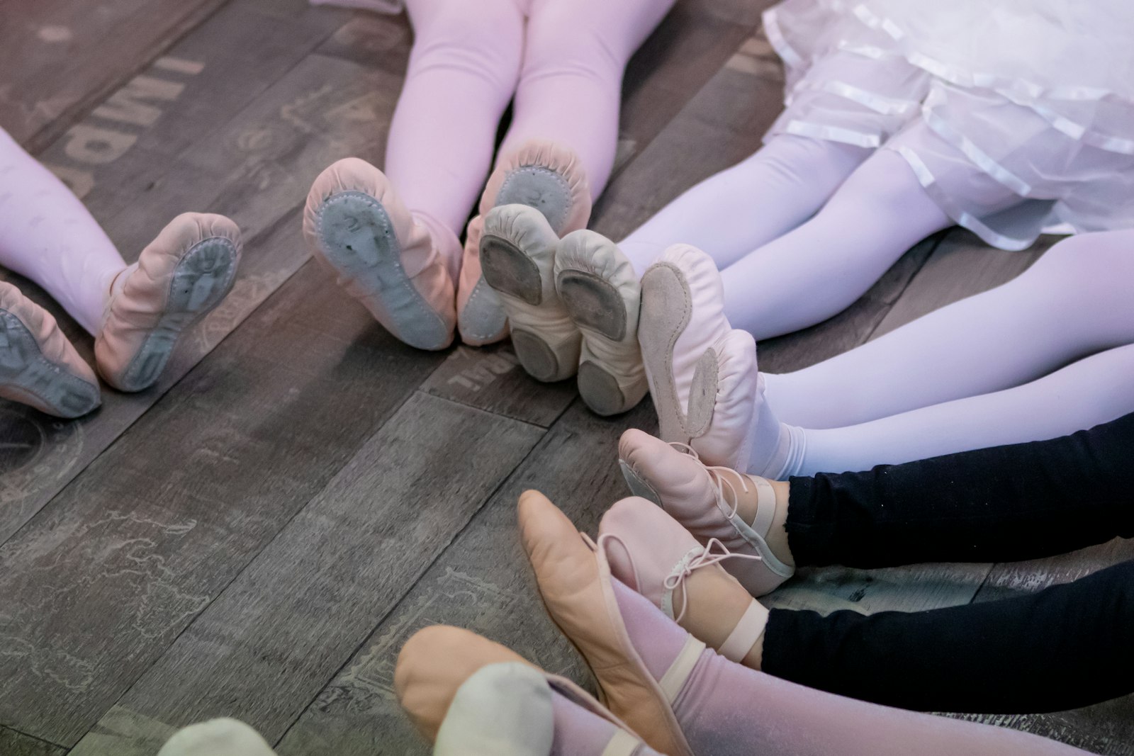 Young dancers’ ballet shoes together in a circle on a studio floor